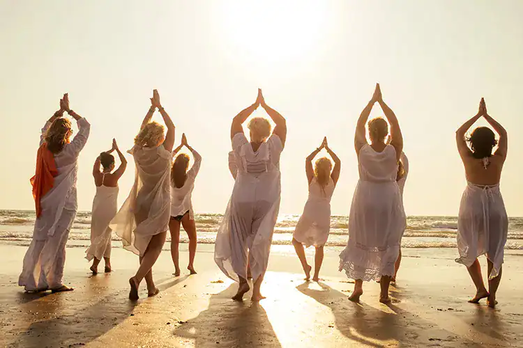 A group of ladies practicing mindfullness at the beach during sunset in Taghazout.